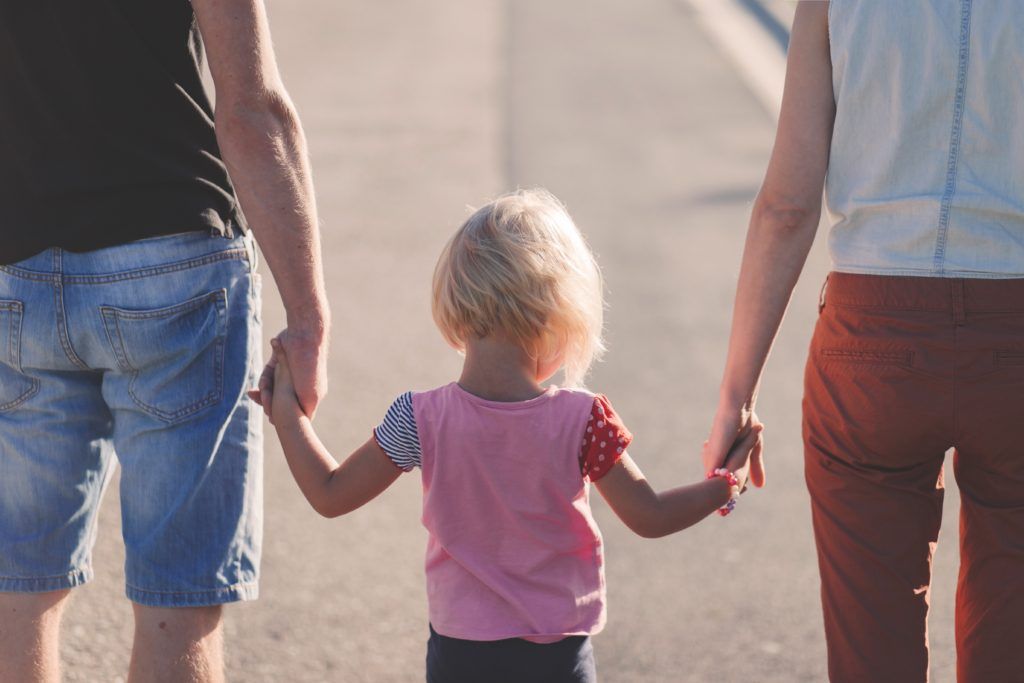 little girl holding parents hands